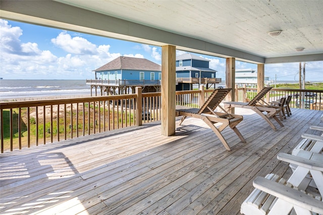 wooden deck with a beach view and a water view