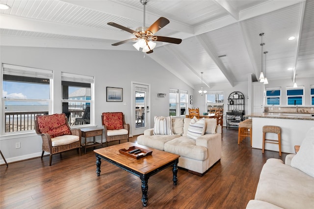 living room featuring dark wood-type flooring, ceiling fan with notable chandelier, lofted ceiling with beams, a water view, and sink