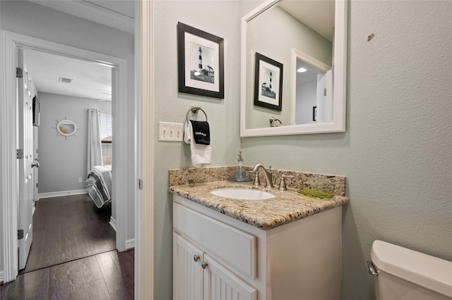 bathroom featuring hardwood / wood-style floors, vanity, and toilet