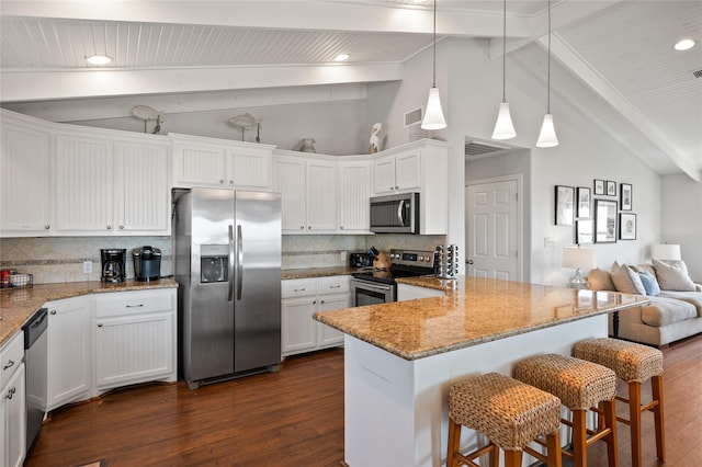 kitchen with white cabinets, stainless steel appliances, a breakfast bar area, and tasteful backsplash