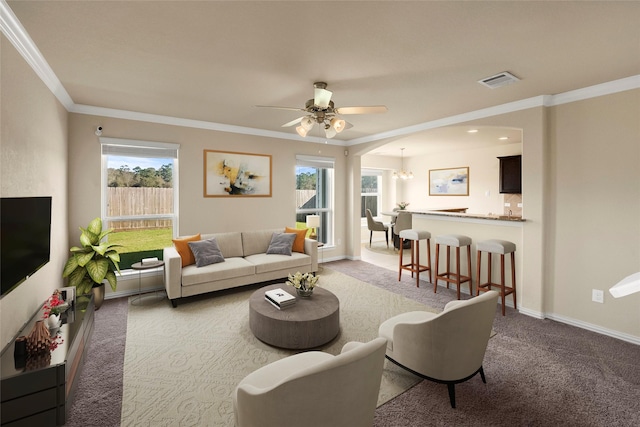 living room with carpet floors, ceiling fan with notable chandelier, and ornamental molding