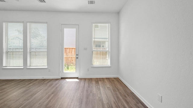 unfurnished room featuring hardwood / wood-style flooring and plenty of natural light