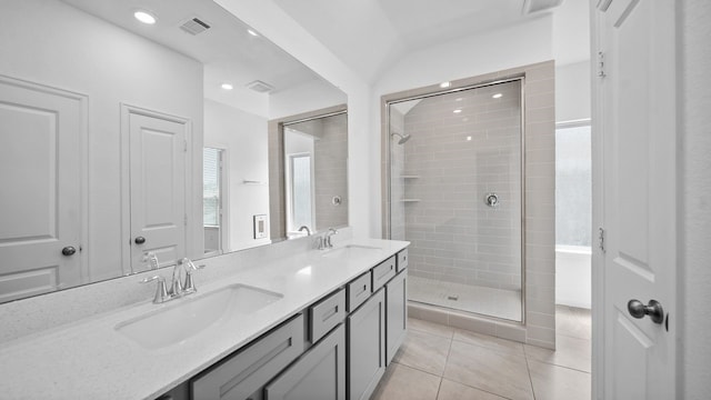 bathroom featuring tile patterned flooring, vanity, a shower with door, and lofted ceiling