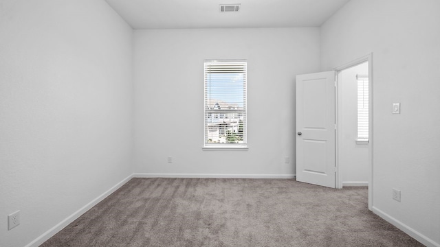 unfurnished room featuring light carpet