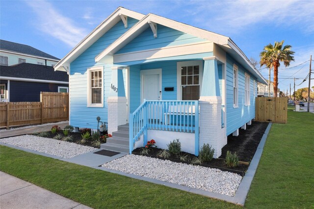 view of front of property with a porch and a front lawn