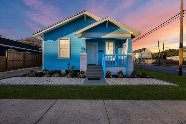 bungalow with a yard and covered porch