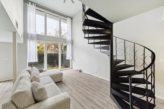 living room featuring light wood-type flooring and a towering ceiling