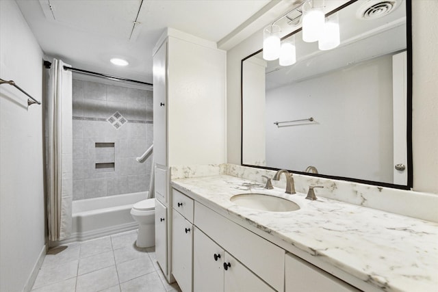 full bathroom featuring tile patterned flooring, vanity, tiled shower / bath combo, and toilet