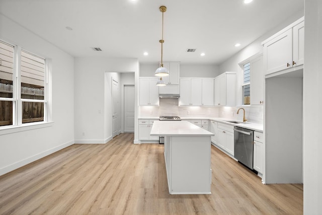 kitchen with dishwasher, a center island, tasteful backsplash, decorative light fixtures, and white cabinetry