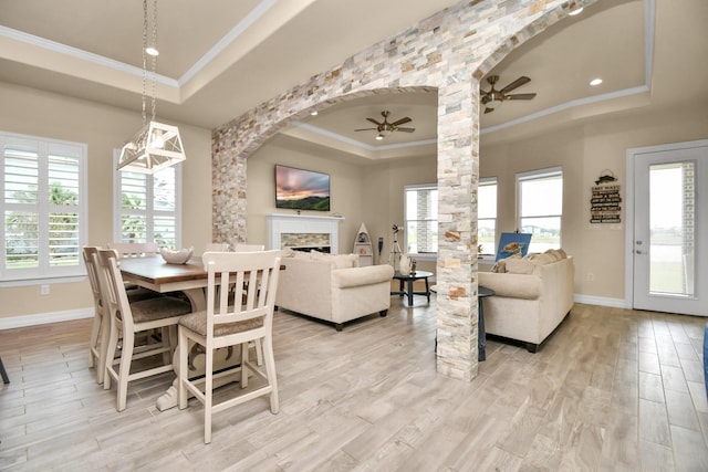 dining area with ornamental molding, a tray ceiling, ceiling fan, and light hardwood / wood-style floors