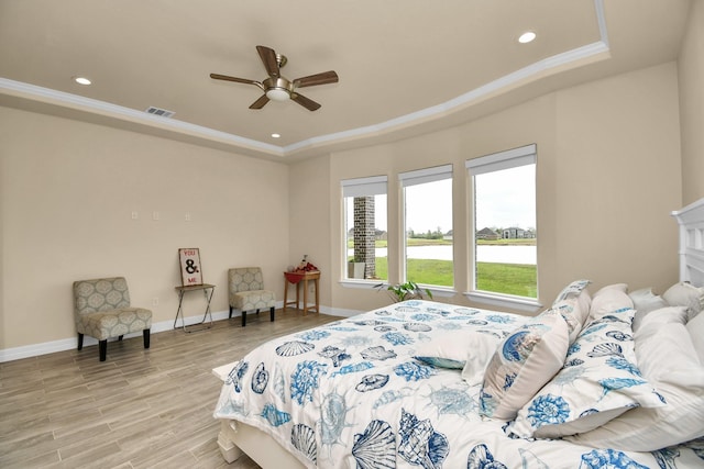 bedroom with a raised ceiling, ceiling fan, light hardwood / wood-style floors, and ornamental molding