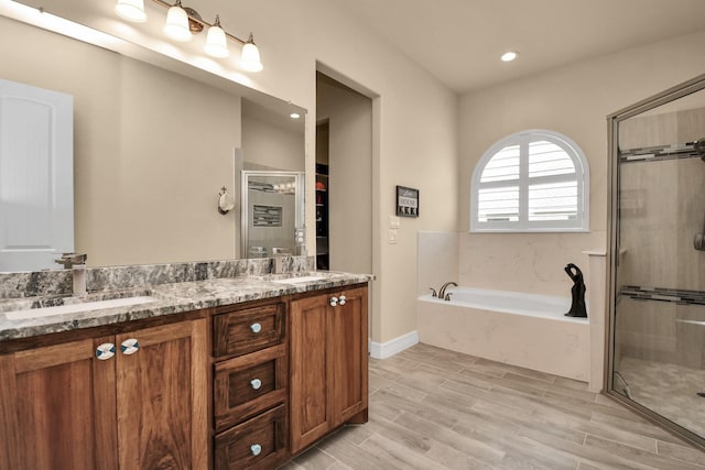 bathroom with vanity, wood-type flooring, and independent shower and bath