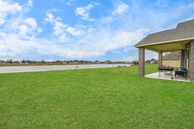 view of yard featuring a patio area and a water view