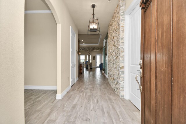 hallway featuring light hardwood / wood-style floors and crown molding