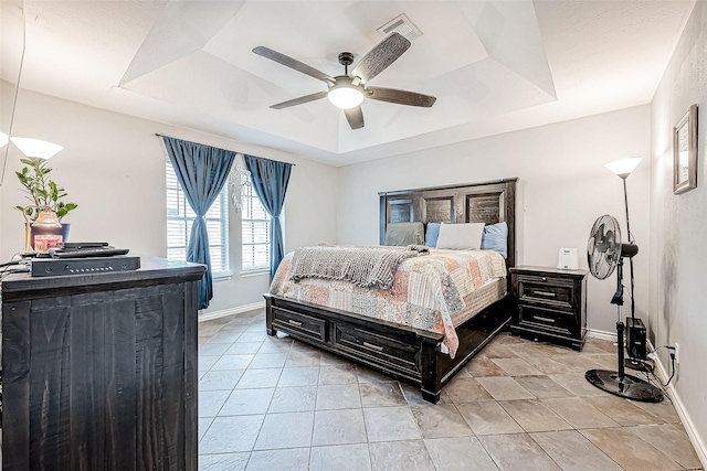 bedroom featuring light tile patterned floors, a raised ceiling, and ceiling fan