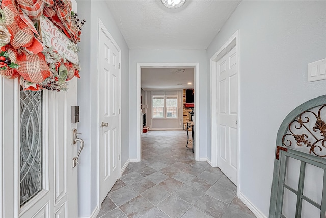 hallway featuring baseboards and a textured ceiling