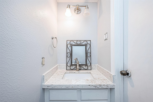 bathroom featuring a textured wall and vanity