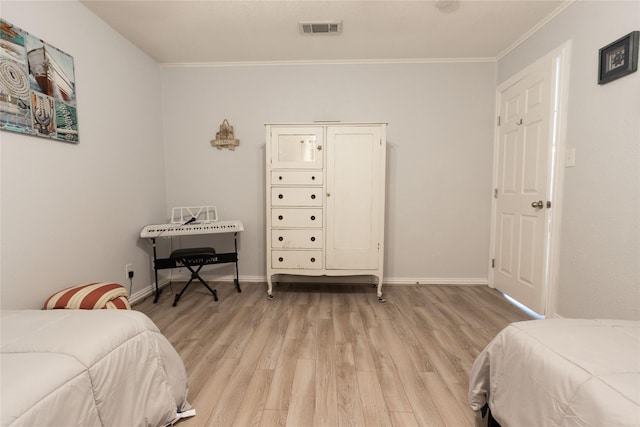 bedroom featuring crown molding and light hardwood / wood-style flooring