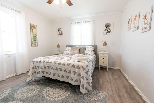 bedroom featuring hardwood / wood-style flooring, ceiling fan, and crown molding