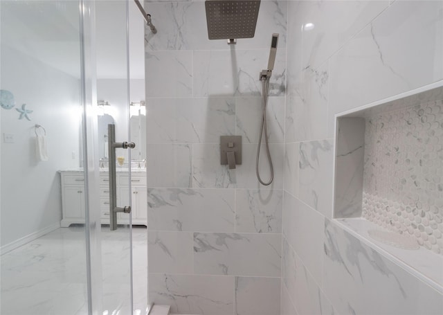 bathroom with a tile shower and vanity