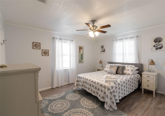 bedroom with multiple windows, a textured ceiling, and dark hardwood / wood-style flooring