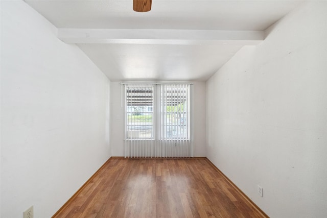 spare room with beam ceiling, ceiling fan, and hardwood / wood-style floors