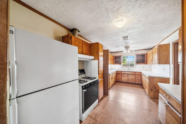 kitchen with ceiling fan, sink, light parquet floors, a textured ceiling, and white appliances