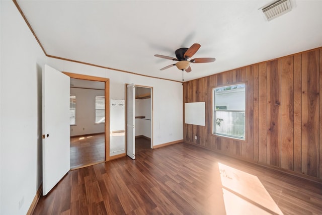 unfurnished bedroom featuring ceiling fan, dark hardwood / wood-style floors, and crown molding