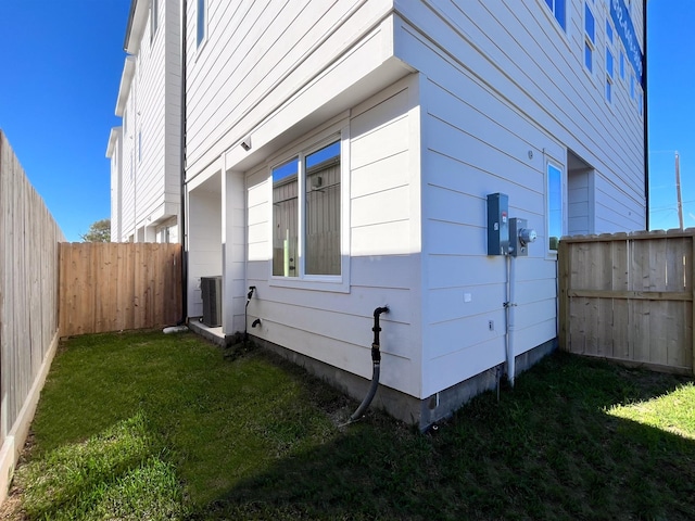 view of home's exterior with a yard and central AC