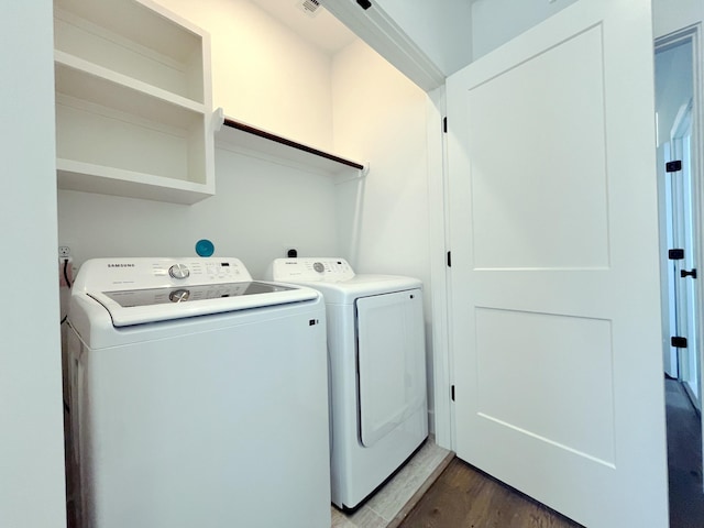 laundry room featuring washing machine and dryer and wood-type flooring