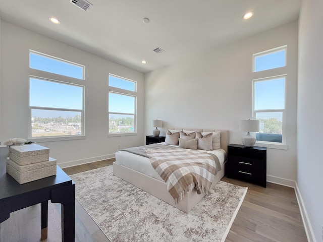 bedroom with multiple windows and light hardwood / wood-style flooring