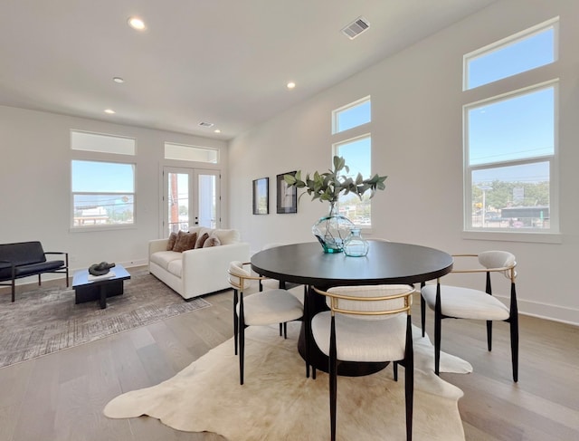 dining area featuring french doors, light wood-type flooring, and a wealth of natural light