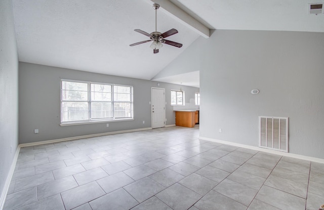 tiled empty room with ceiling fan, beam ceiling, plenty of natural light, and high vaulted ceiling