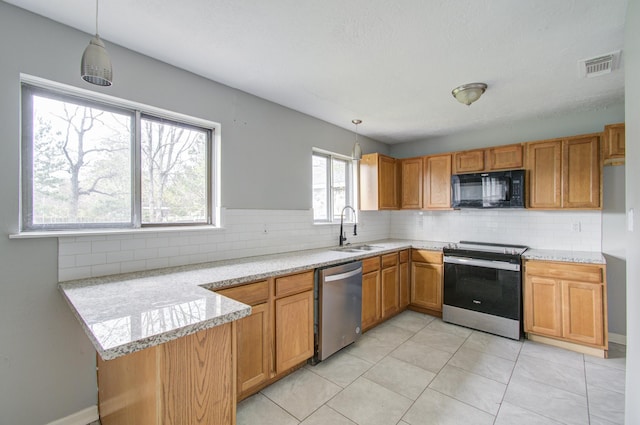 kitchen with pendant lighting, sink, light tile patterned floors, appliances with stainless steel finishes, and kitchen peninsula