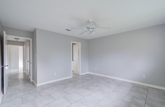 tiled spare room with ceiling fan