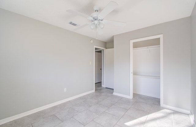 unfurnished bedroom with ceiling fan, light tile patterned flooring, and a closet