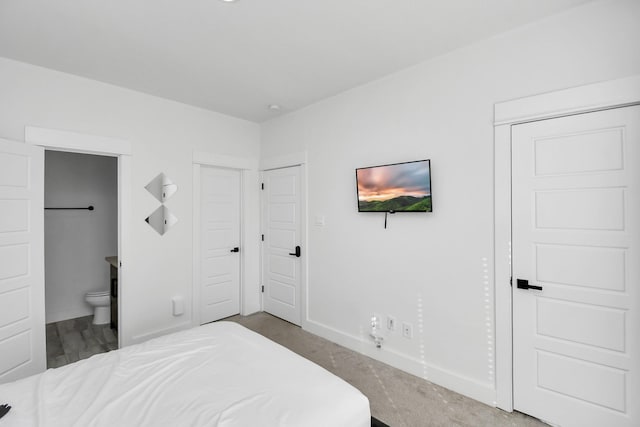 carpeted bedroom featuring ensuite bath