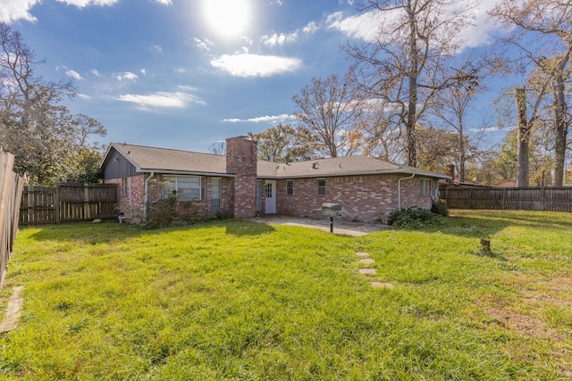 rear view of house with a yard and a patio area