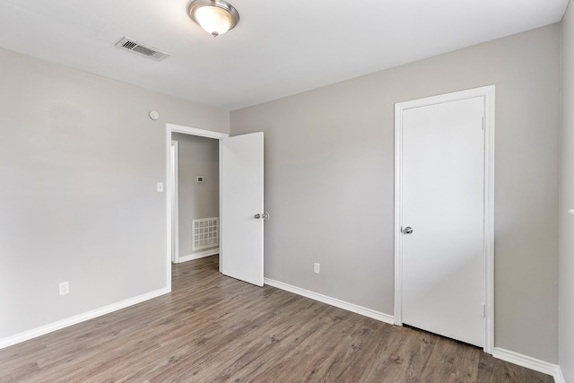 spare room featuring wood-type flooring