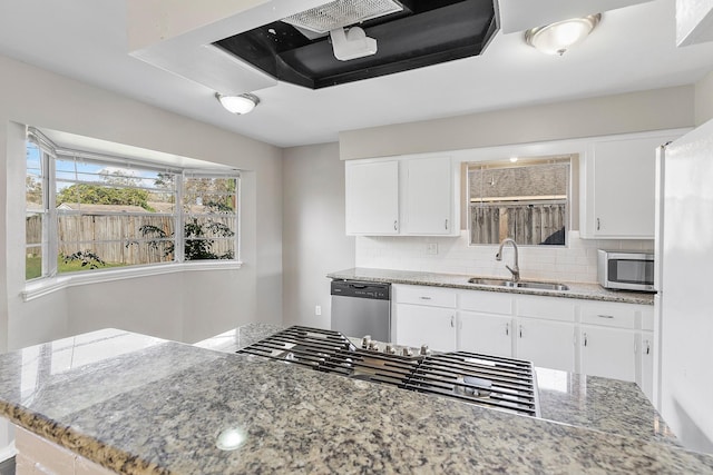 kitchen featuring white cabinets, sink, light stone countertops, tasteful backsplash, and stainless steel appliances