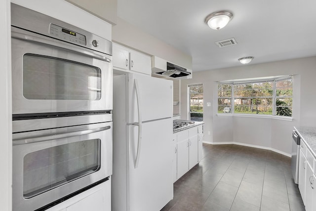 kitchen featuring light stone counters, white cabinets, and stainless steel appliances