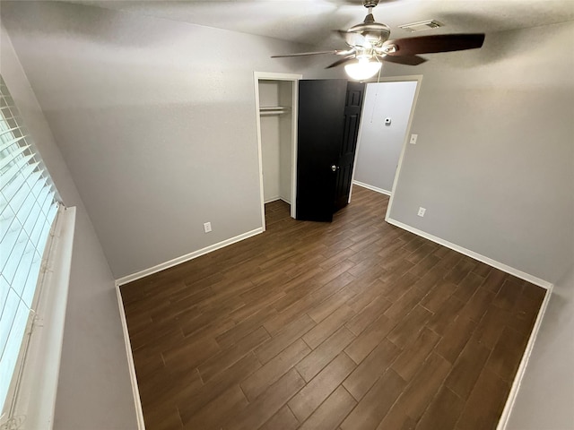 unfurnished bedroom featuring dark hardwood / wood-style flooring, ceiling fan, and a closet