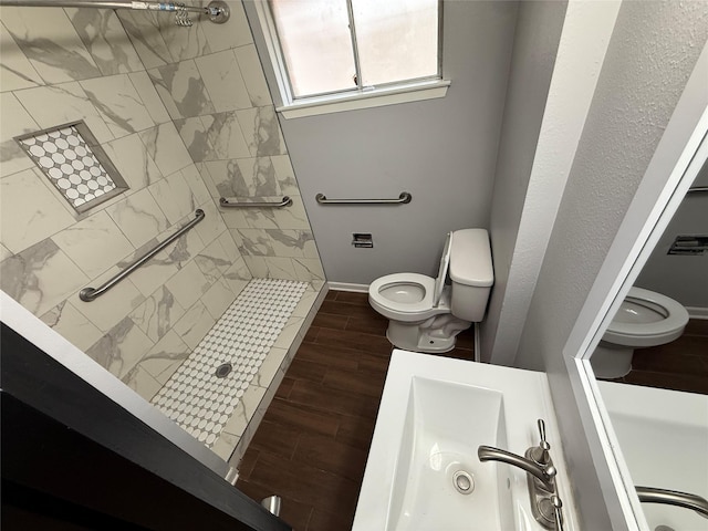 bathroom with toilet and a tile shower