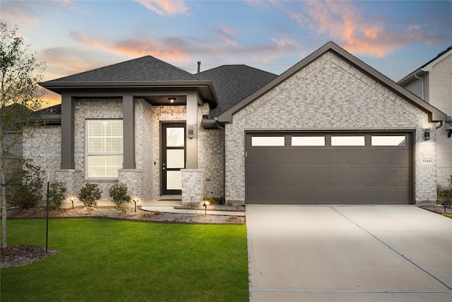 view of front of property with a yard and a garage