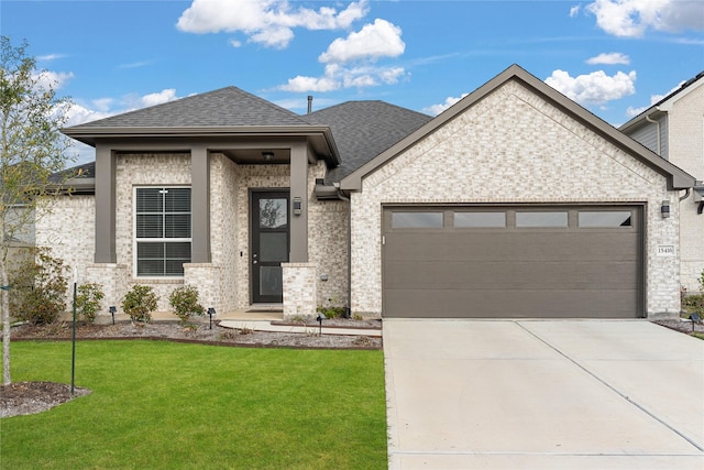 view of front of house featuring a garage and a front lawn