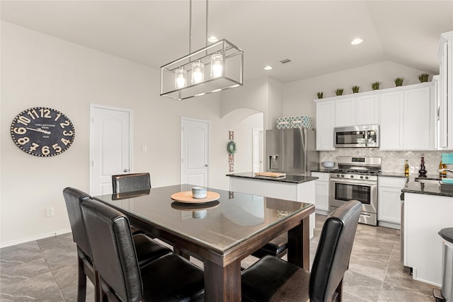 dining room featuring sink and vaulted ceiling