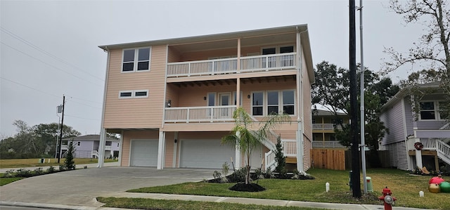 view of front of house featuring a balcony, a front lawn, and a garage