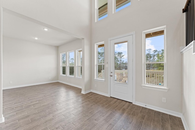 entryway with a towering ceiling and light hardwood / wood-style flooring