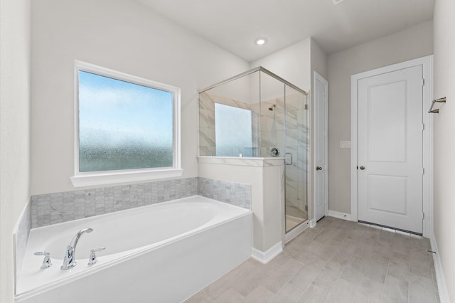 bathroom featuring shower with separate bathtub