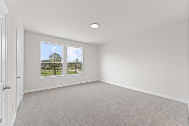 unfurnished room featuring light colored carpet